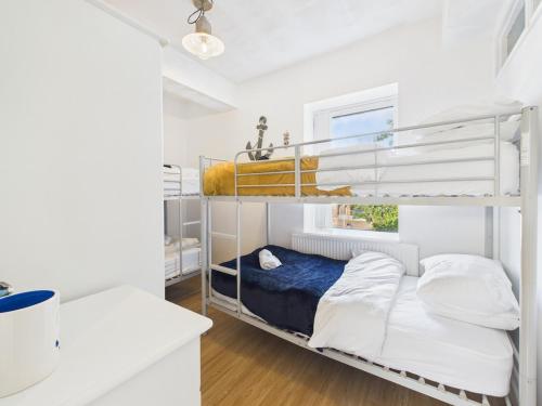 a bedroom with two bunk beds and a window at Harbour Haven Steps from Torquay Port in Torquay