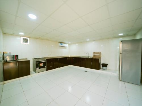 a large kitchen with a large white tile floor at Palm Escape Farmhouse - By Seven Elements in Ras al Khaimah