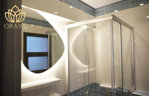 ein Badezimmer mit Dusche und Spiegel in der Unterkunft Modern & Bright Getaway in Madinaty in Banī Ghālib