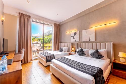a hotel room with two beds and a window at Glenence Nuwara Eliya in Nuwara Eliya