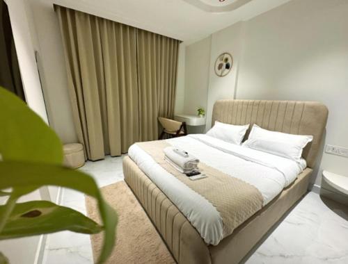 a bedroom with a bed with a phone on it at Lux Living Hotel in Bengaluru