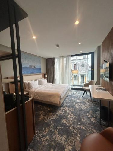ein Hotelzimmer mit einem Bett und einem großen Fenster in der Unterkunft Piazza Epigraph in Batumi