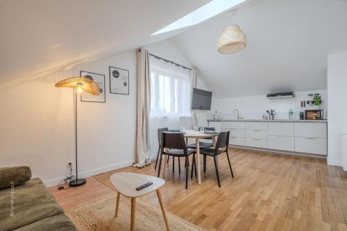 a living room with a table and chairs and a kitchen at Home designed Especially for Groups in Vaires-sur-Marne