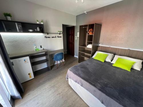 a bedroom with a large bed with green pillows at Rezende Suítes in Balneário Camboriú