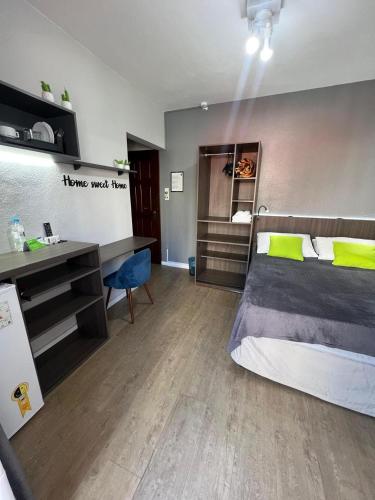 a bedroom with a bed and a desk and a desk at Rezende Suítes in Balneário Camboriú