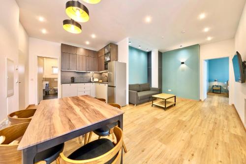 a kitchen and living room with a wooden table and chairs at COZEE - Design-Wohnung mit Parkplatz zwischen München und Flughafen MUC in Ismaning