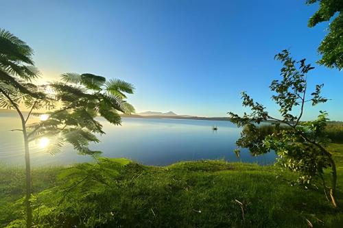 a view of a lake with the sun setting at Beach Bungalow Saquarema in Ipitangas