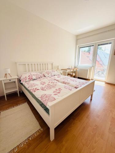 a bedroom with a bed and a table and a window at Srdce Mesta 1 - zážitkový apartmán Na Pešej Zóne s balkónom a terasou in Gerlachov