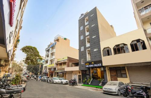 ニューデリーにあるHotel The King Palaceの車や建物が停まる街道