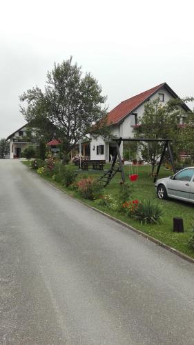 a house with a car parked on the side of a road at Guest House Adrijana in Seliste Dreznicko