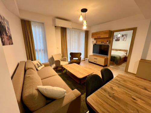 a living room with a couch and a television at Titik Apartments Mavrovo in Mavrovo