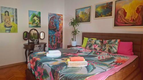 a bed in a room with paintings on the wall at Stylish King Downtown in Podgorica