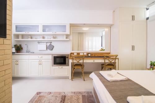 eine Küche mit weißen Schränken und ein Bett in einem Zimmer in der Unterkunft HaBaitBe Matityahu By Domus in Be’er Scheva