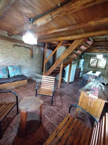 ein Raum mit Bänken und einem Tisch in einem Gebäude in der Unterkunft Alquiler en Villa Yacanto in Villa Yacanto