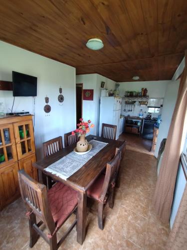 ein Esszimmer mit einem Holztisch und Stühlen in der Unterkunft Alquiler en Villa Yacanto in Villa Yacanto