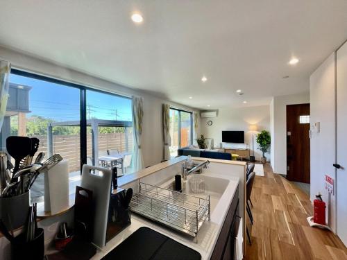 une cuisine avec un évier et une grande fenêtre dans l'établissement Lohas Resort 芥屋A, à Itoshima