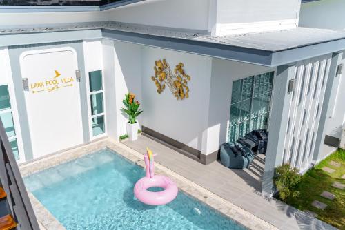 a house with a swimming pool with a pink flamingo in it at Lark Pool Villa Aonang Krabi in Ao Nang Beach