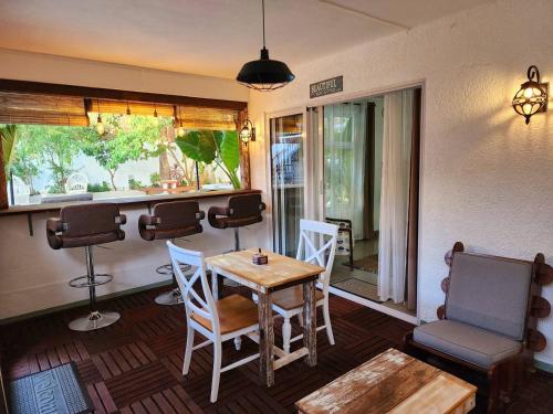 a room with a table and chairs and a window at Cozy 1 Bedroom Apt with Pool & 3mins Walk to Beach - TRR4 in Pointe aux Canonniers