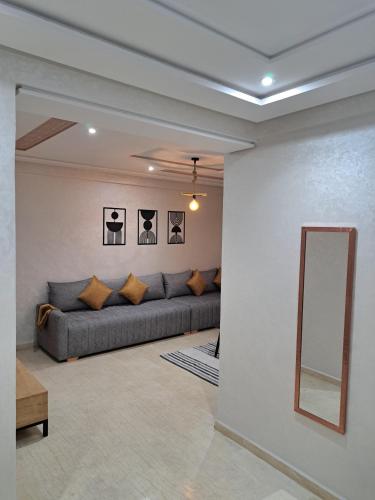 a living room with a couch and a mirror at Appartement Au Centre Ville Prés de la Medina in Fez