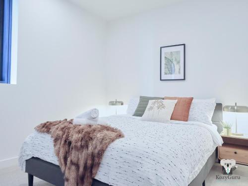 Un dormitorio con una cama con una manta de piel. en KozyGuru | Box Hill | Chic & Close to It All, en Box Hill