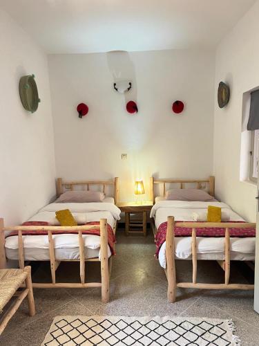 a room with two beds and a table in a room at Berber RIAD with big terrace in Aourir