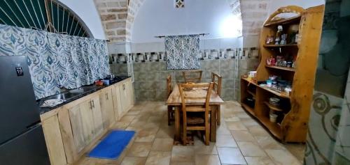 eine Küche mit einem Tisch und einem Waschbecken sowie einem Tisch und Stühlen in der Unterkunft Beach House Kilifi in Kilifi