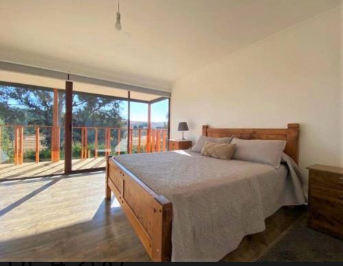 a bedroom with a large bed and a balcony at Maitencillo, amplía y cómoda casa, con piscina y hoy tub in Puchuncaví