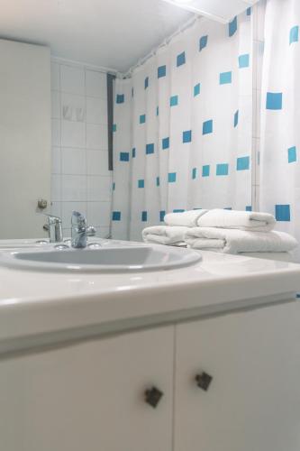 a bathroom with a white sink and a mirror at Apart Hotel Sendero del Sol in La Serena