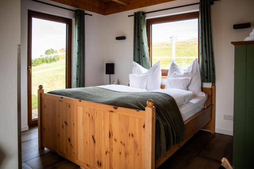a bedroom with a wooden bed with a large window at Chalet Landsitz in Dippoldiswalde