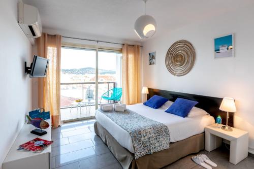 a bedroom with a bed and a large window at Sweett - Maison Blanche I in Juan-les-Pins