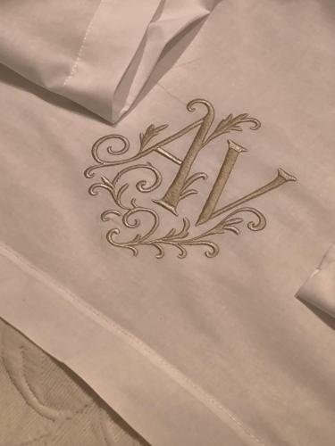 a cursive letter k embroidered on a wedding dress at Aromas do Vouga in São Pedro do Sul