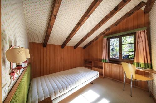 a bedroom with a bed and a desk and a window at House under the beeches- Casa sotto i Faggi in Locarno