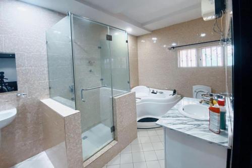 a bathroom with a glass shower and a sink at 5 Bed Penthouse Sleeps 10 - All Ensuite - Garden in Lagos