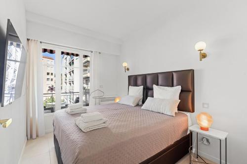 Un dormitorio con una cama grande con toallas. en 3 pièces Juan les Pins Cosy et Luxueux, en Juan-les-Pins