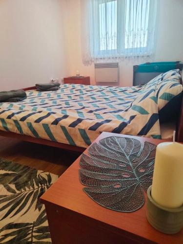 a bedroom with a bed and a table with a candle at Look Apartman in Vrnjačka Banja