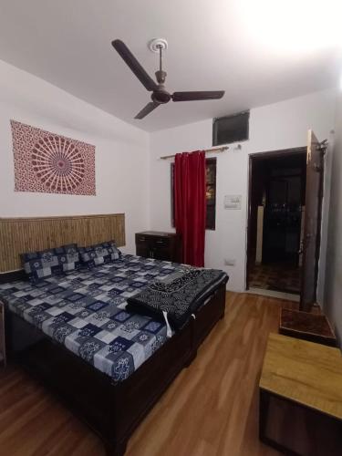 a bedroom with a bed and a ceiling fan at Happy Shiva Cefe & Homestay in Rishīkesh