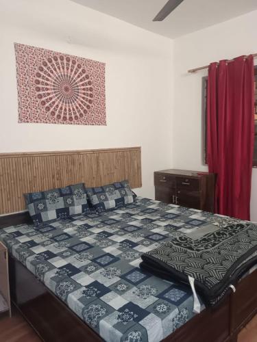 a bedroom with a bed with a quilt on it at Happy Shiva Cefe & Homestay in Rishīkesh