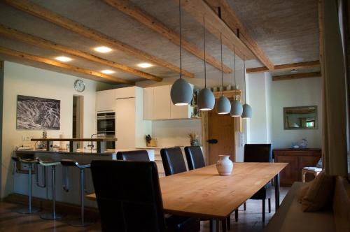 een keuken en eetkamer met een houten tafel en stoelen bij Chalet Fluh in Schindelberg
