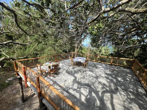 a patio with a table and chairs on a deck at Kimulimuli Green Heaven in Kilindoni