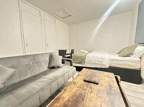 a living room with a couch and a bed at Spacious Double Room By Town Centre in Stevenage