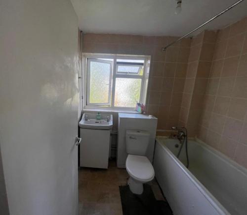 a bathroom with a toilet and a sink and a tub at Spacious Double Room By Town Centre in Stevenage