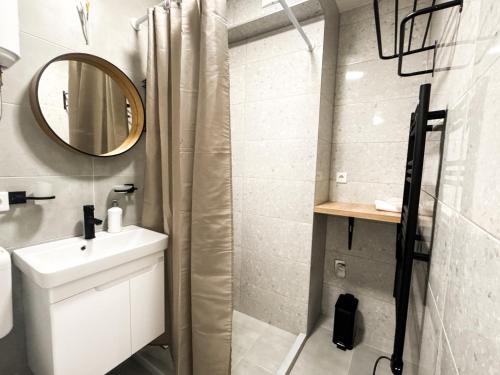 ein weißes Badezimmer mit Waschbecken und Spiegel in der Unterkunft Ma Bel Apartments Sarajevo in Sarajevo