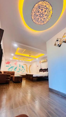 a living room with a bed and a painting on the ceiling at Hotel Ajitgarh in Jhunjhunūn