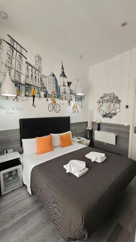 a bedroom with a large bed with a painting on the wall at Hostal Lauria in Madrid