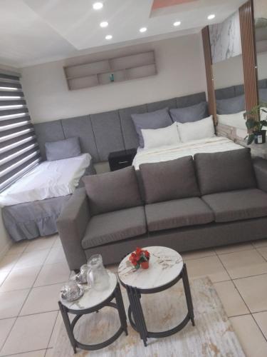 a living room with a couch and two tables at Viva Guest House in Trevallyn