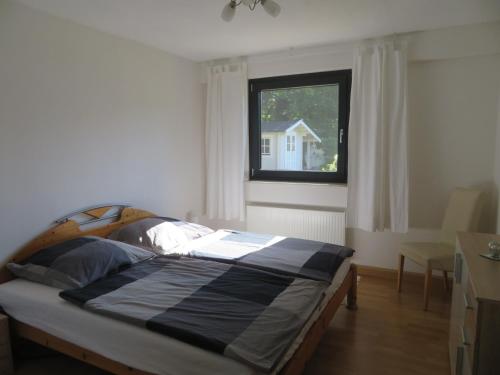 a bed in a room with a window at Ferienwohnung Vollmarshausen in Lohfelden