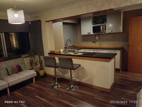 a kitchen with a counter and two chairs in a room at Open space studio in Shawlands in Glasgow