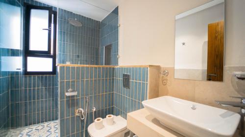 a bathroom with a sink and a toilet and a mirror at Aurora Piscine Chauffée à quelques pas de la mer in El Haouach