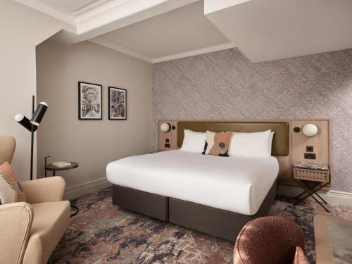 a bedroom with a large white bed and a couch at The Met Hotel Leeds - Newly Refurbished in Leeds