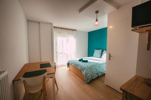 ein Schlafzimmer mit einem Bett, einem Tisch und einem Schreibtisch in der Unterkunft Mon joli studio - Pessac in Pessac